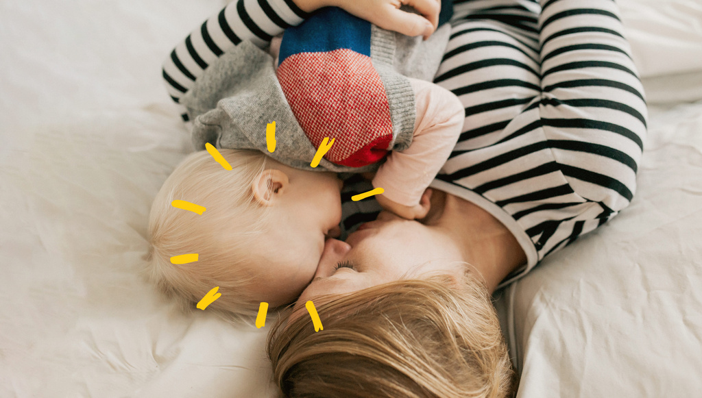 cute baby and mother cuddling on bed sunshine