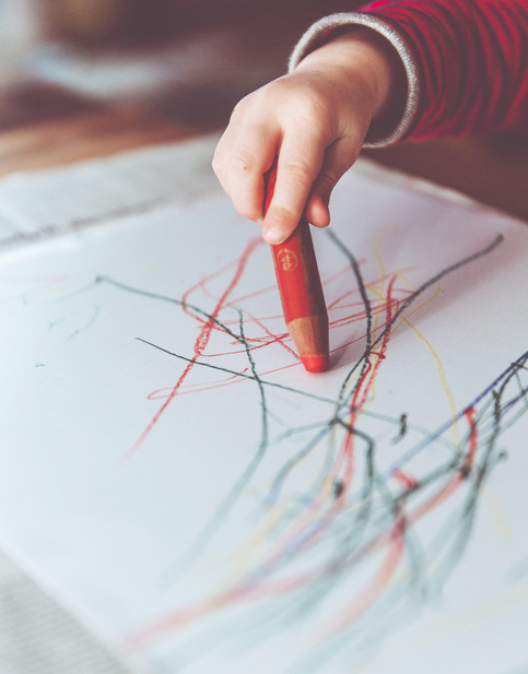 baby scribling with colour pencils on a paper