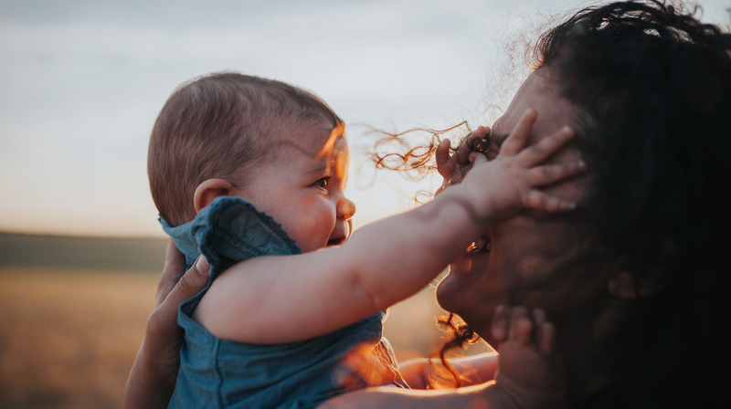 baby girl reaching for her mom