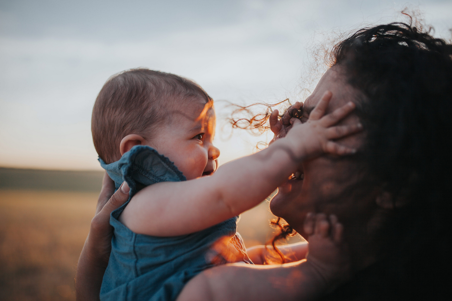 baby girl reaching for her mom